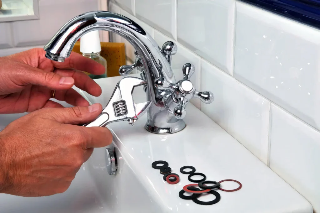 Plumber performing maintenance on a bathroom faucet in Jurupa Valley