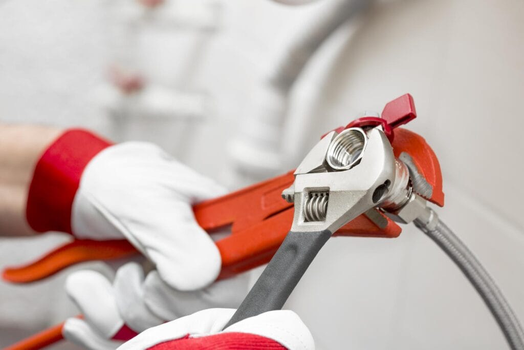 Plumber holding pipe wrenches for an emergency repair in Jurupa Valley