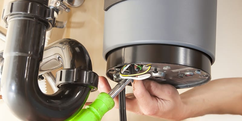 Technician repairing the heating element of a water heater in Jurupa Valley