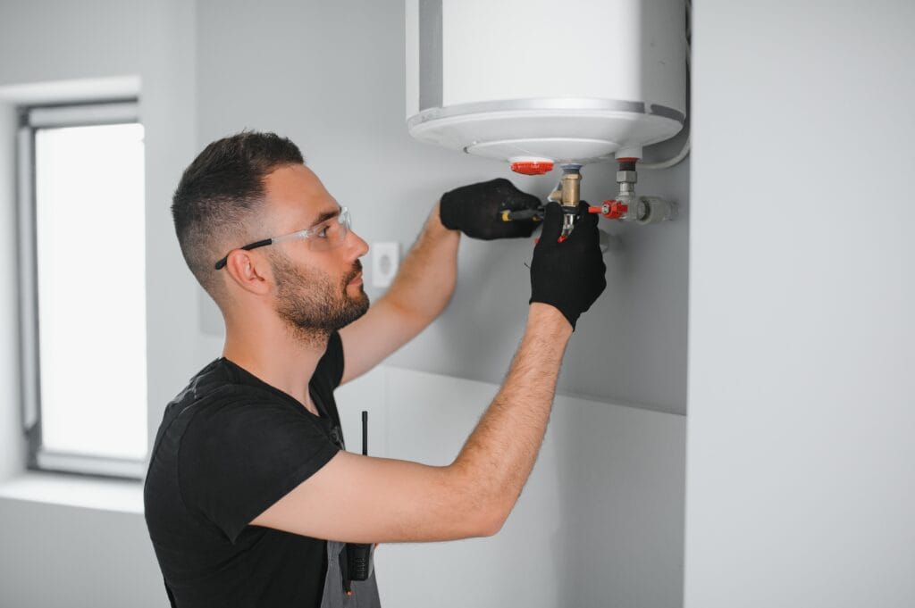 Technician performing water heater maintenance in Jurupa Valley