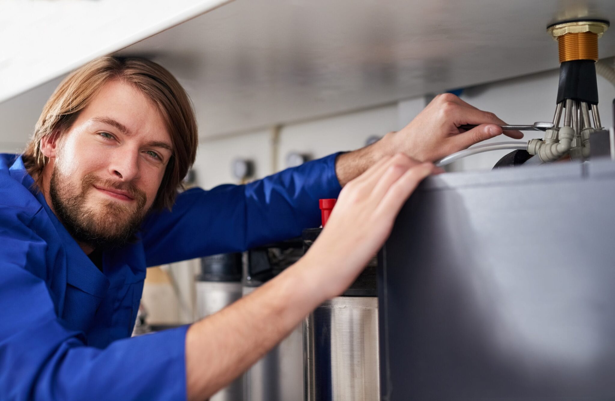 Technician servicing a residential water heater tank in Jurupa Valley
